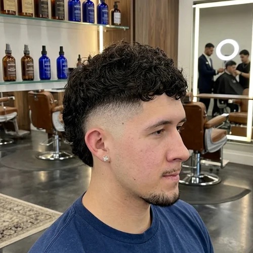 Man featuring a high burst fade mullet with curly hair top