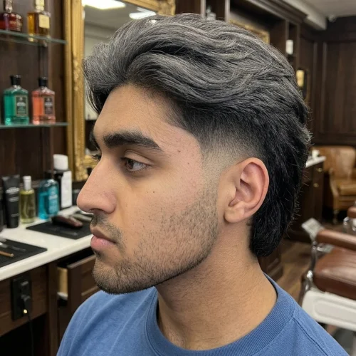Side profile of a young man with a mid burst fade mullet haircut